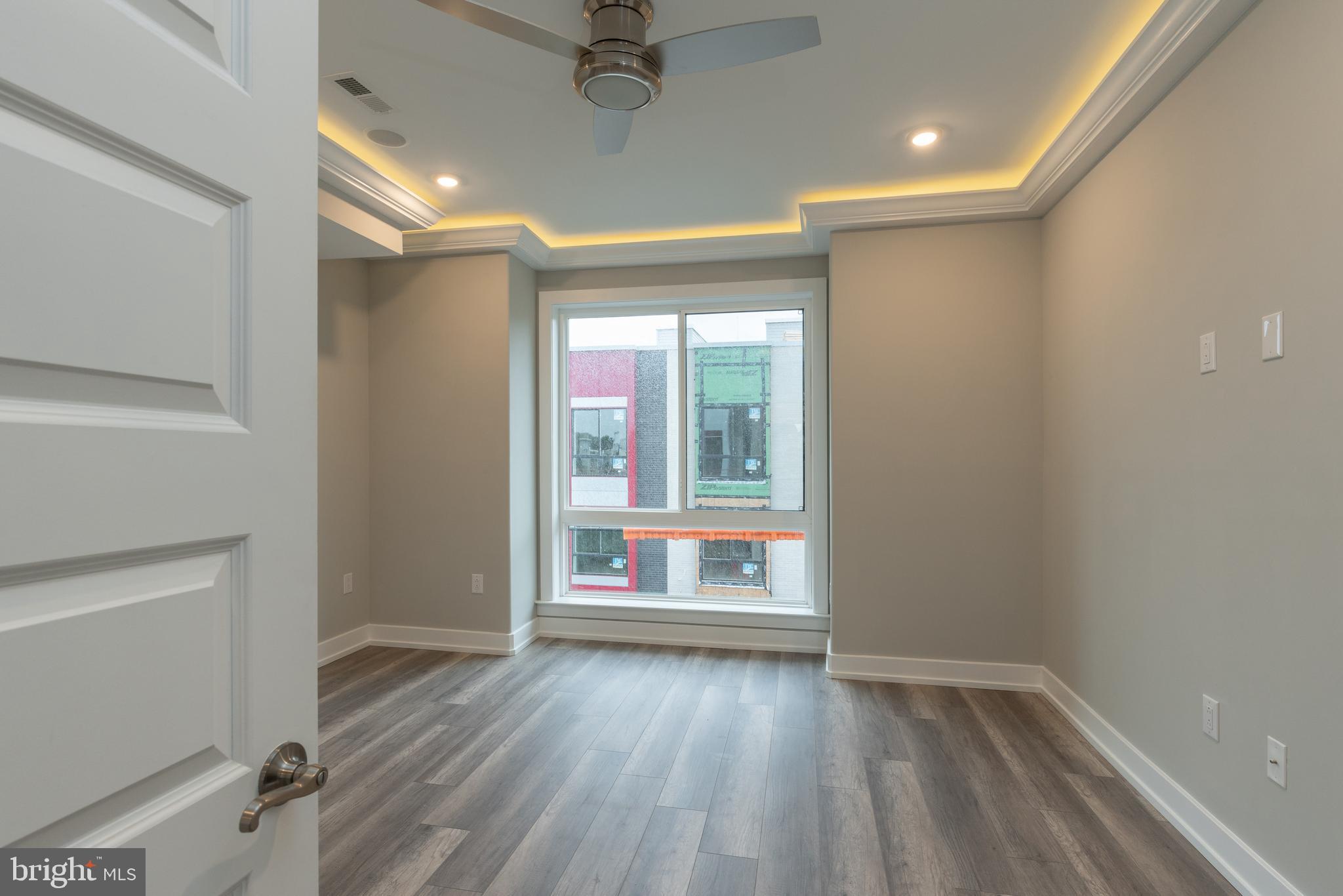 135 West Huntingdon Street, Unit 2 Philadelphia, PA 19133 - Photo 12 of 29 an empty room with wooden floor and windows