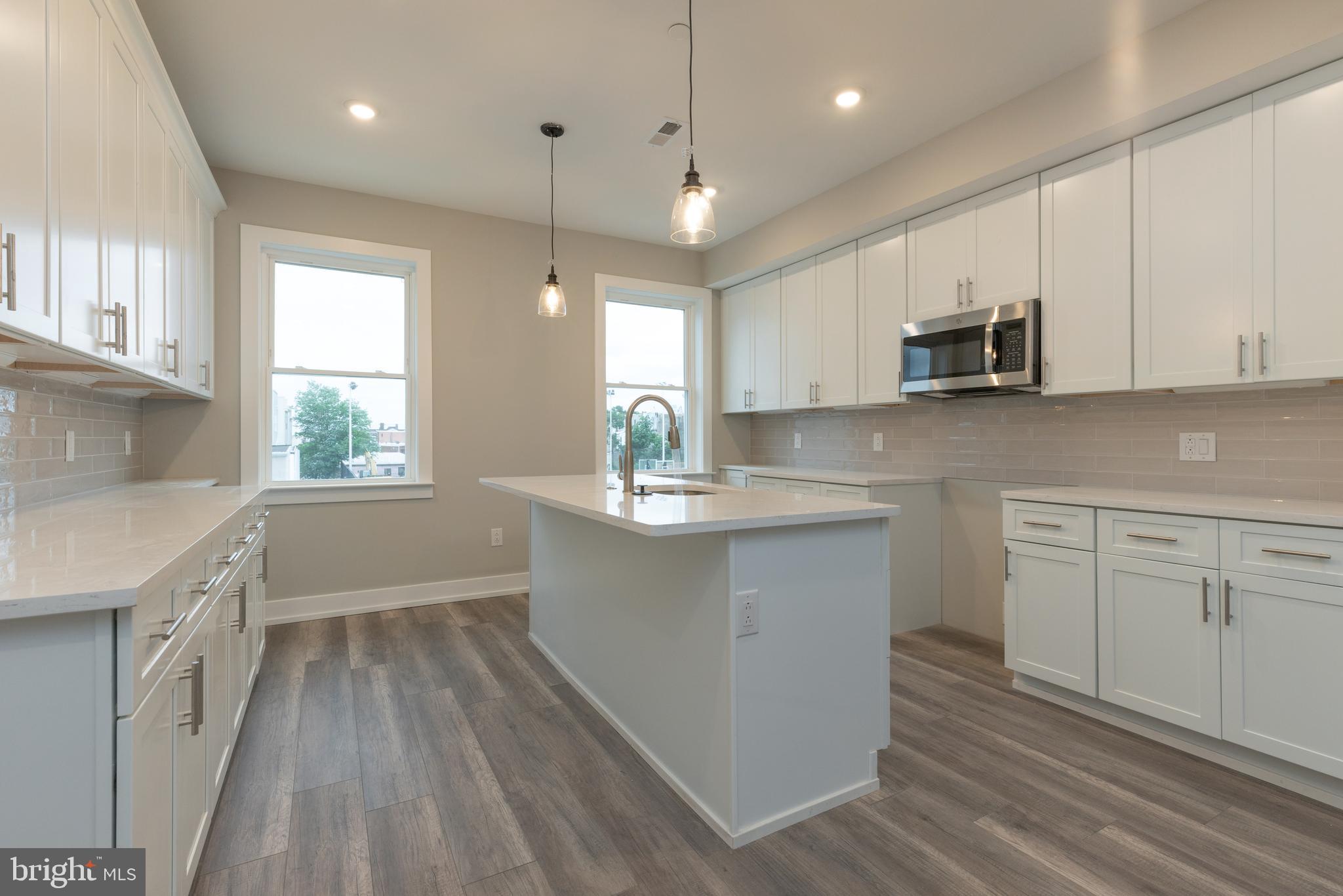 135 West Huntingdon Street, Unit 2 Philadelphia, PA 19133 - Photo 4 of 29 a kitchen with kitchen island white cabinets and window