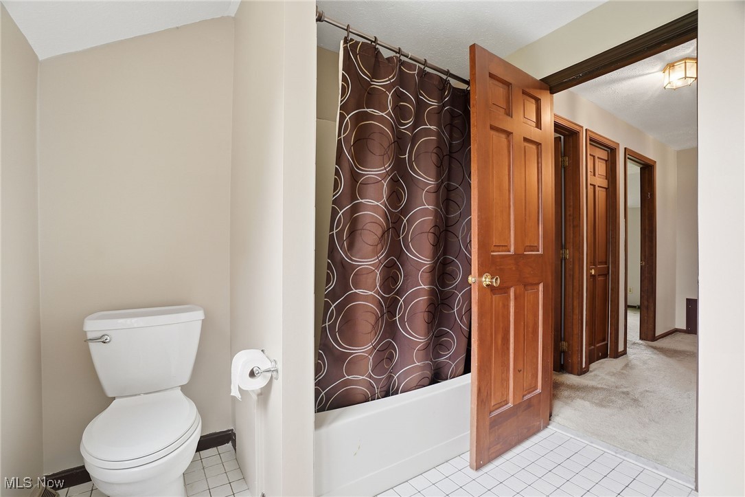 11710 Butternut Road Chardon, OH 44024 - Photo 33 of 48 Full bath featuring light tile patterned floors, shower / bath combo with shower curtain, and light colored carpet