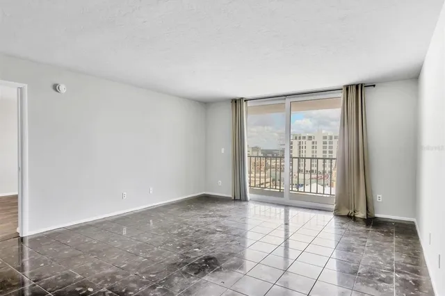 a view of an empty room with wooden floor and closet