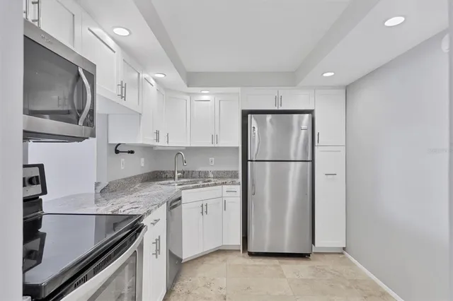 a kitchen with cabinets stainless steel appliances a sink and a counter space