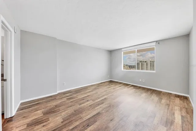 a view of empty room with wooden floor