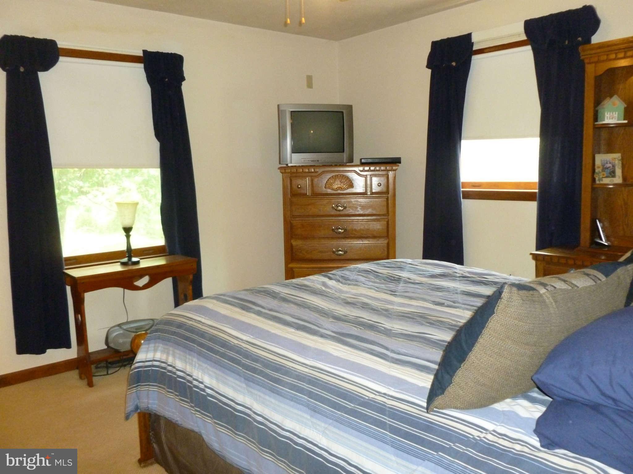 5762 Howellsville Road Front Royal, VA 22630 - Photo 15 of 22 a bedroom with a bed and a flat tv screen next to a window
