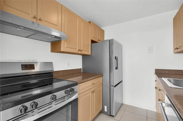 a kitchen with stainless steel appliances granite countertop a refrigerator and a stove top oven