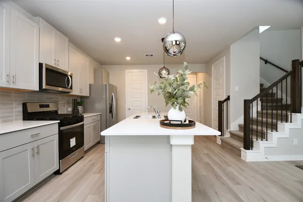 a kitchen with a sink stainless steel appliances and cabinets
