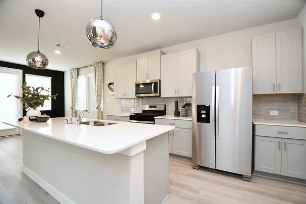 a kitchen with refrigerator cabinets and wooden floor