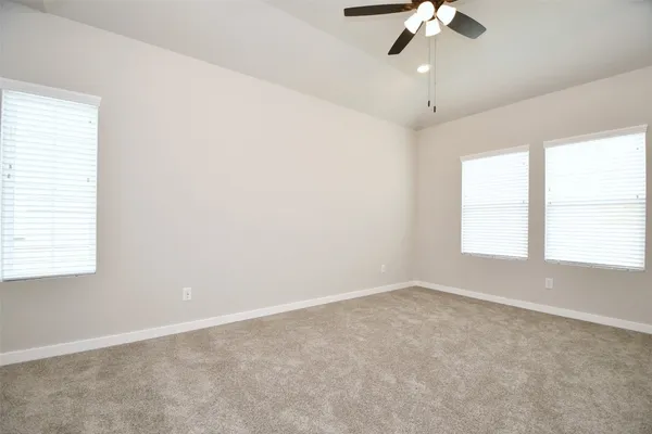an empty room with a window and a fan