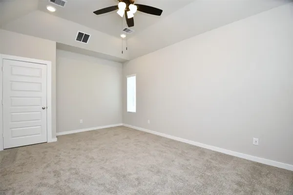 an empty room with a chandelier fan and closet