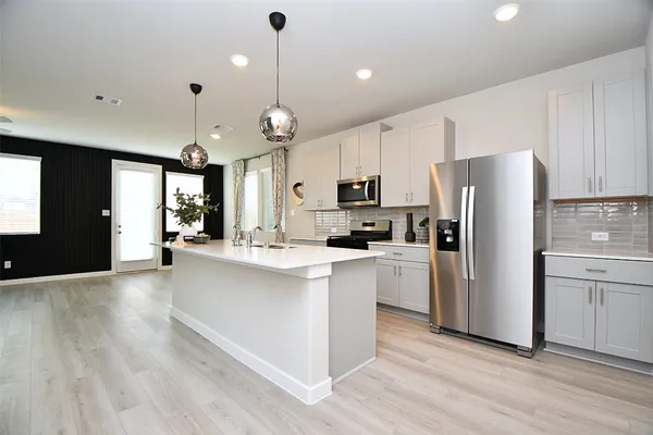a kitchen with stainless steel appliances a refrigerator sink and microwave