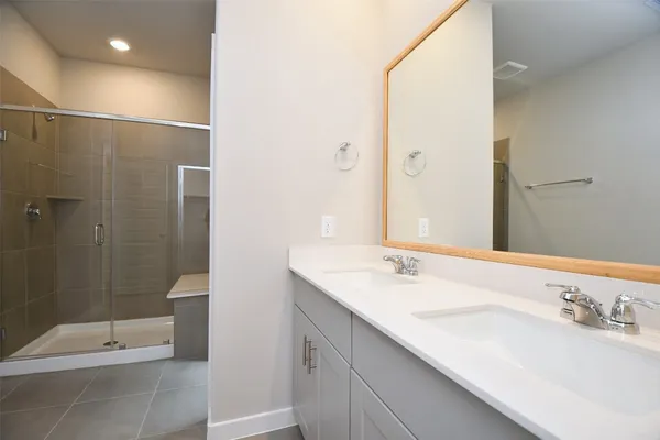 a bathroom with a double vanity sink toilet and shower
