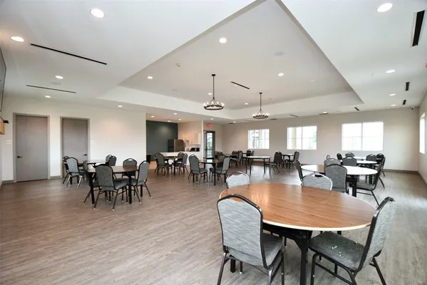 a dining room with lots of furniture wooden floor and chandelier