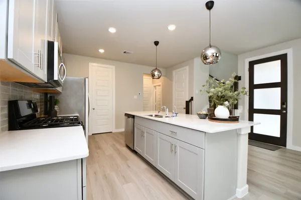 a kitchen with stainless steel appliances a sink stove and refrigerator
