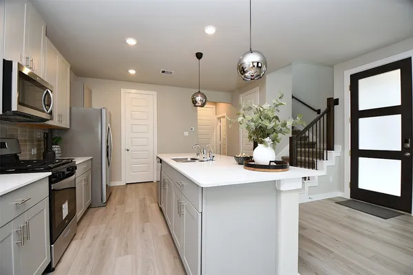 a kitchen with a stove a sink and a refrigerator