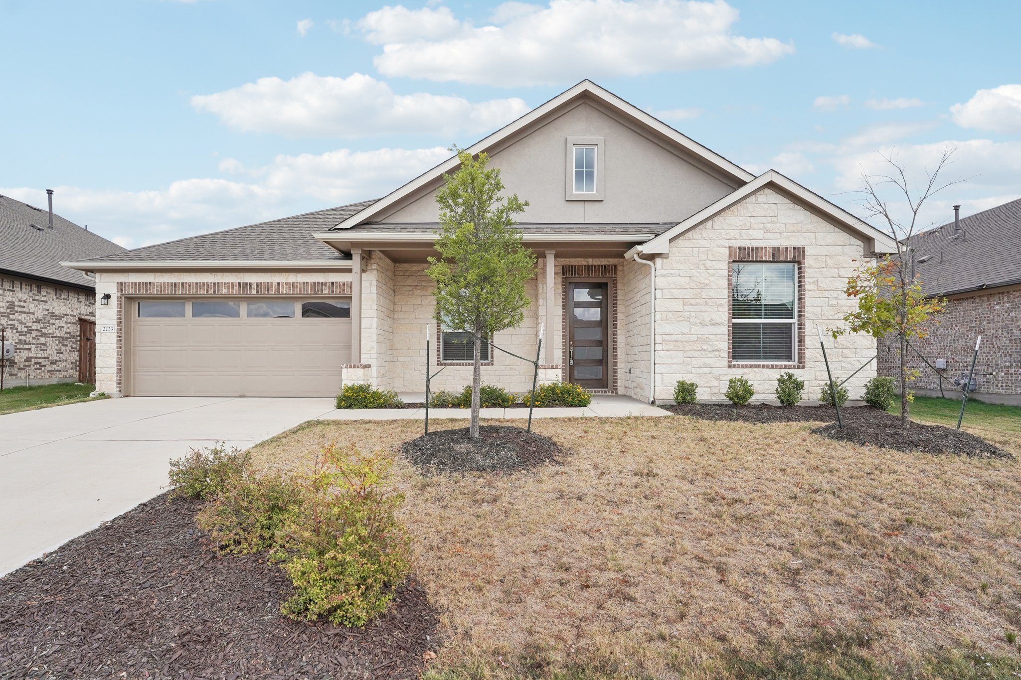 2233 Bravo Pass Leander, TX 78641 - Photo 1 of 33 View of front facade with driveway, an attached garage, a porch, roof with shingles, and stucco siding