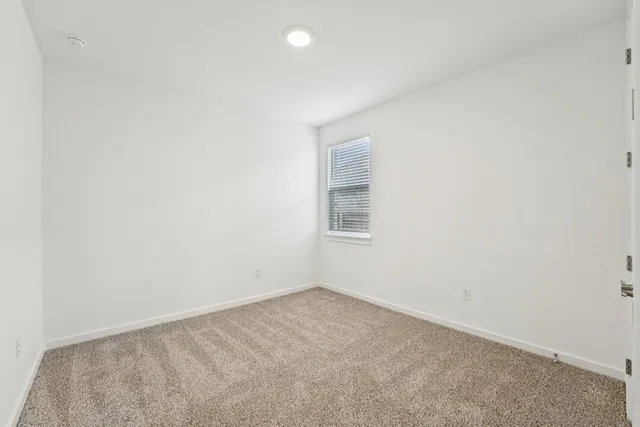 a large white kitchen with wooden floors stainless steel appliances and white cabinets