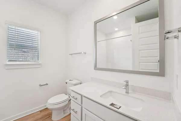 a large white kitchen with sink a refrigerator and wooden cabinets