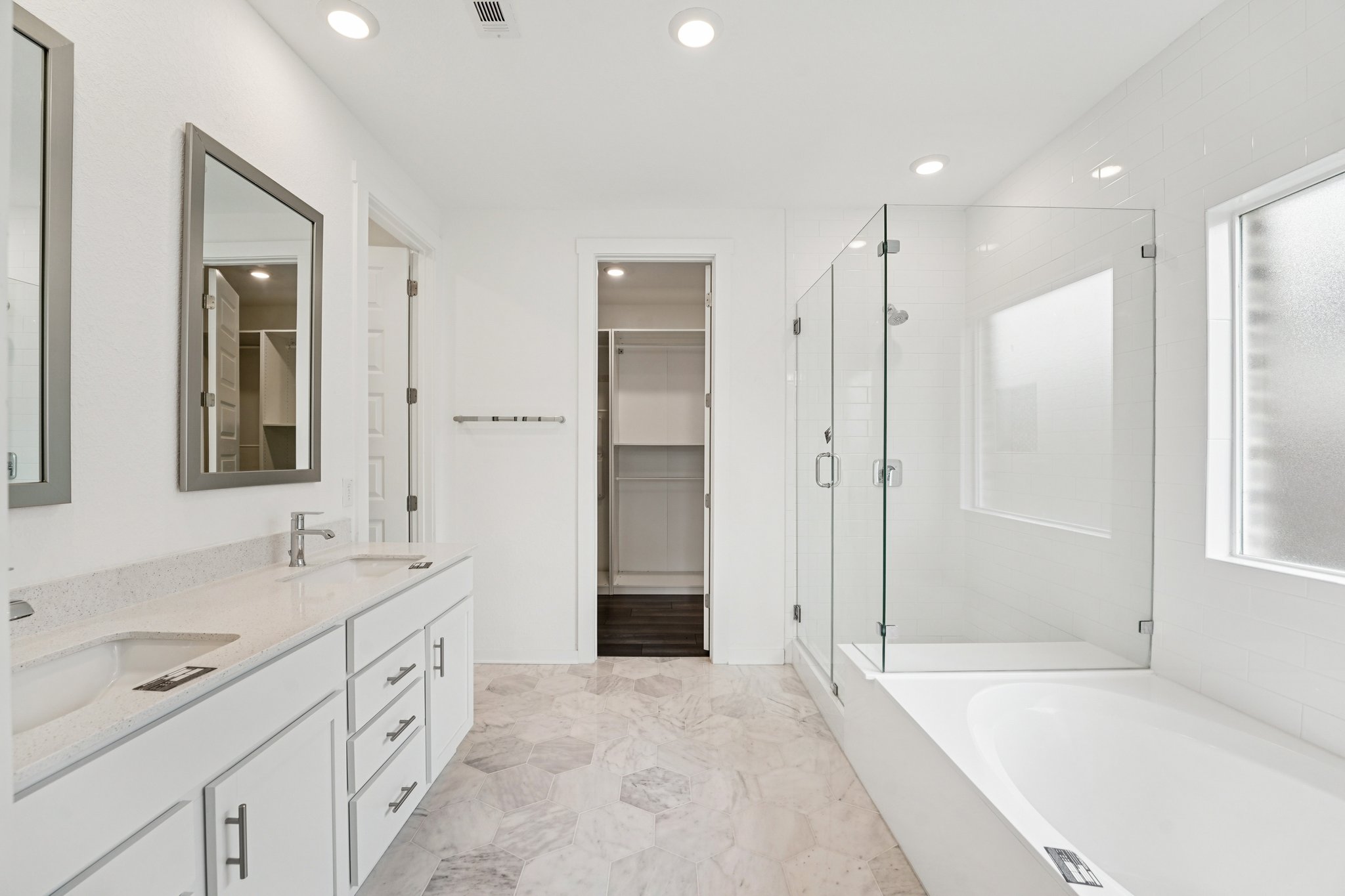 2233 Bravo Pass Leander, TX 78641 - Photo 17 of 33 Full bathroom featuring healthy amount of natural light, a garden tub, double vanity, a stall shower, and recessed lighting