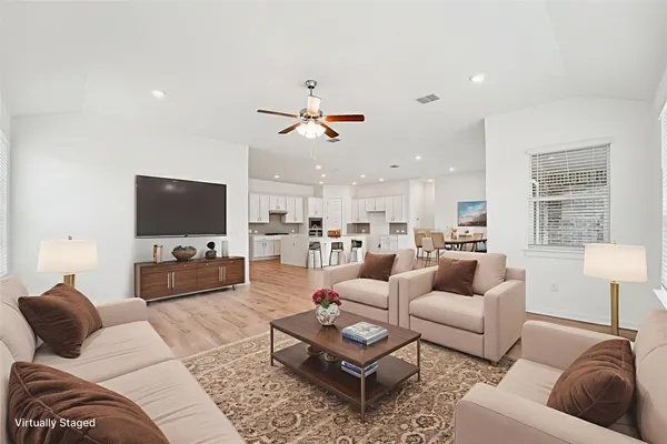 a living room with furniture a flat screen tv and a large window