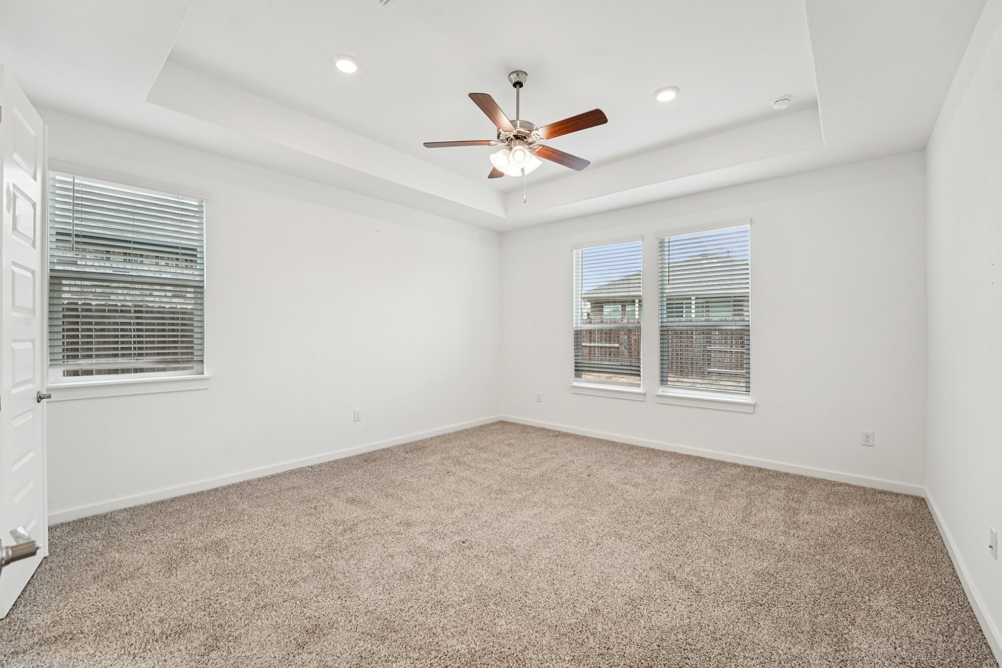 2233 Bravo Pass Leander, TX 78641 - Photo 28 of 33 Spare room featuring a tray ceiling, light colored carpet, and recessed lighting