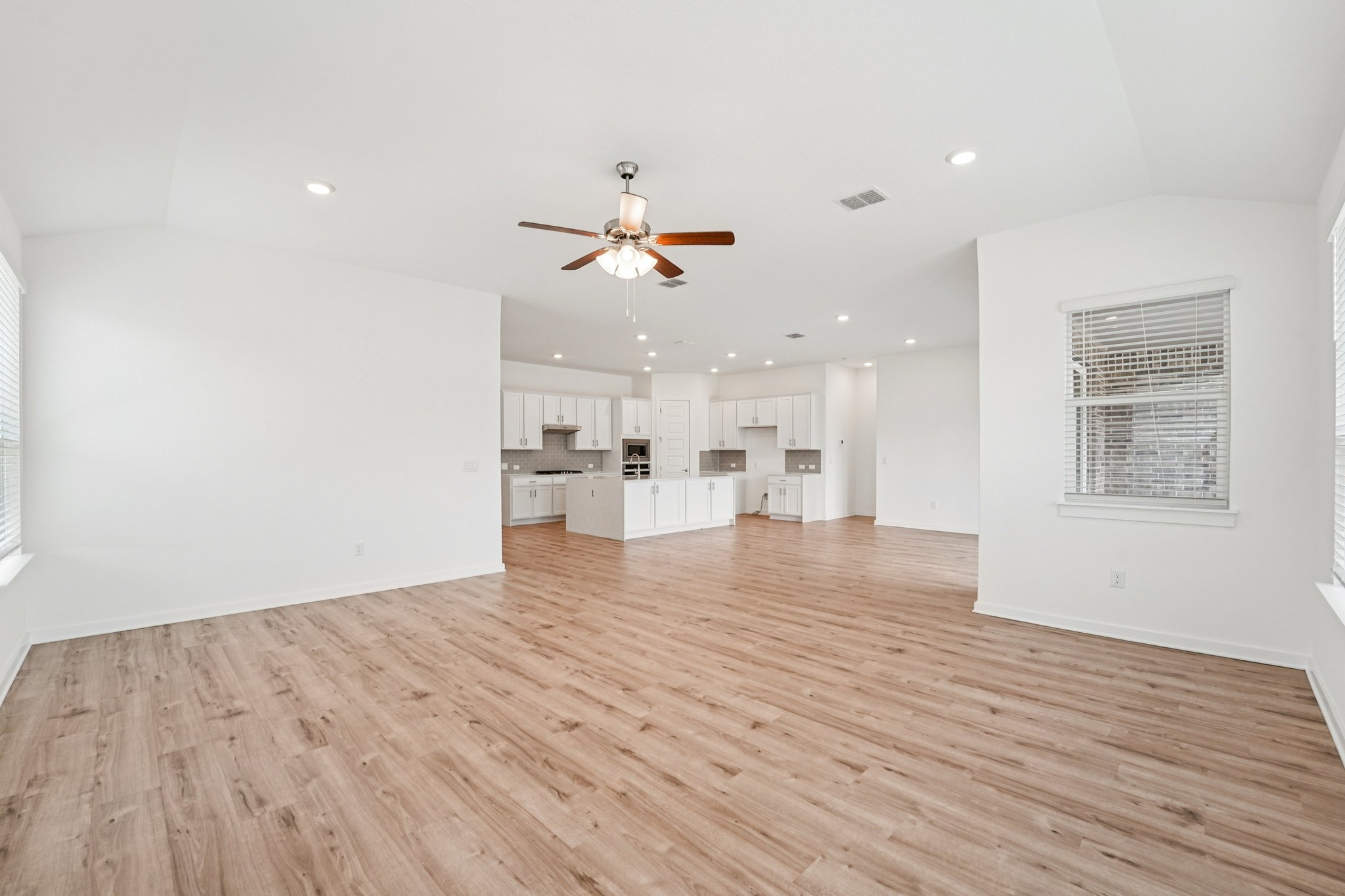 2233 Bravo Pass Leander, TX 78641 - Photo 7 of 33 Unfurnished living room featuring light wood finished floors, a ceiling fan, recessed lighting, and vaulted ceiling