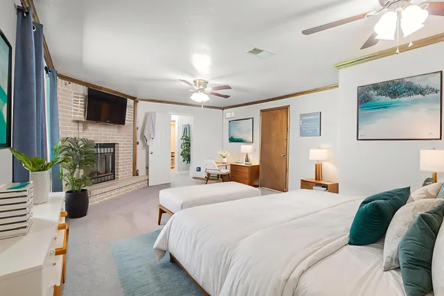 a bedroom with a bed a flat screen tv and a fireplace