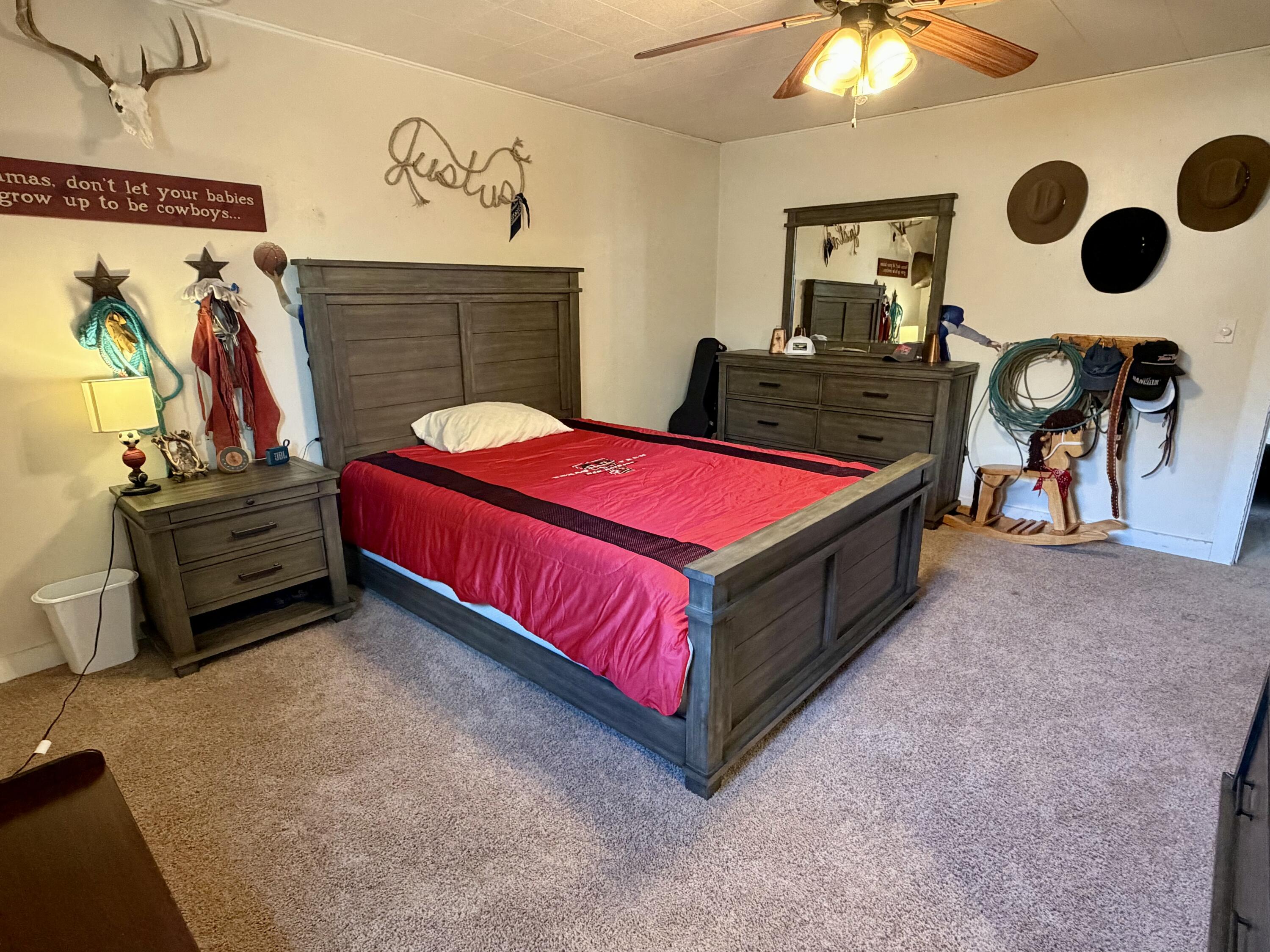 207 2nd Street Quitaque, TX 79255 - Photo 7 of 9 a spacious bedroom with a bed and a chandelier