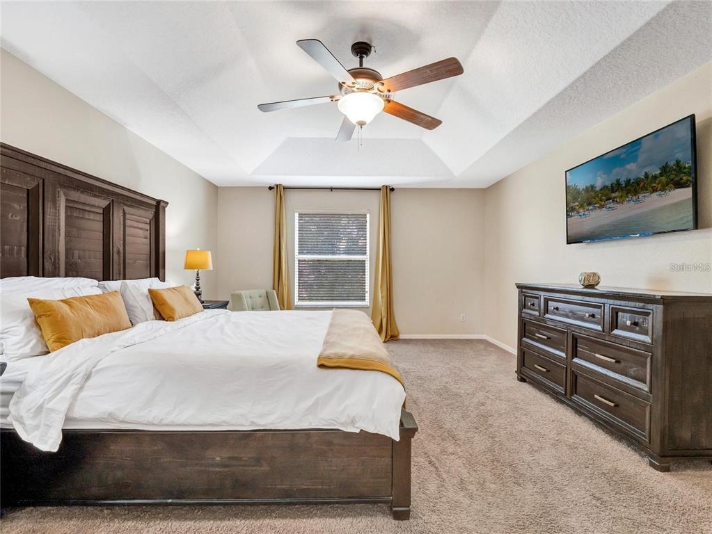10023 Ians Ridge Road Orlando, FL 32832 - Photo 27 of 60 a bedroom with a bed and a flat screen tv