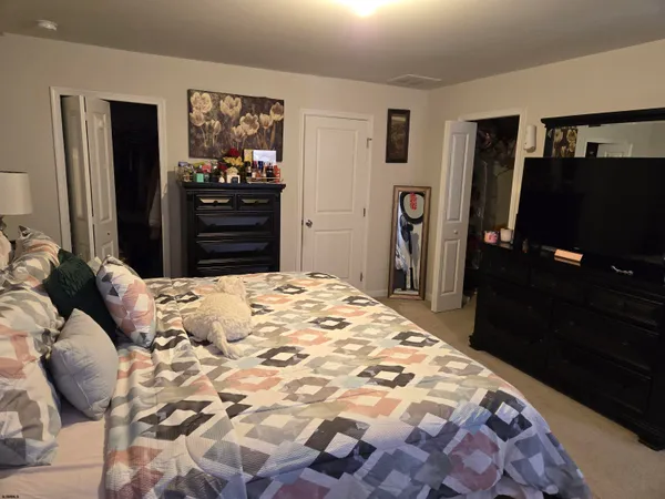 a bedroom with a bed and a flat tv screen