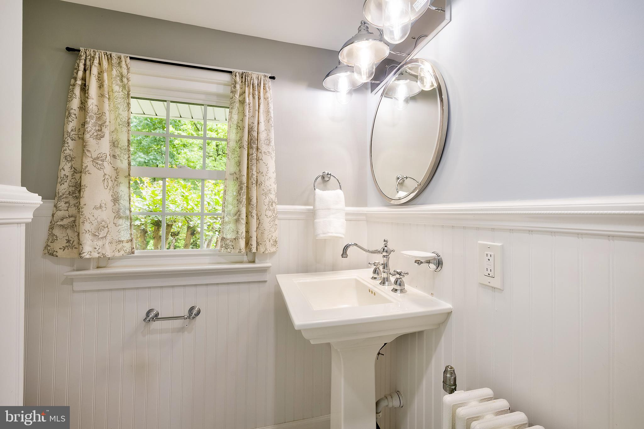 2925 Covington Road Silver Spring, MD 20910 - Photo 29 of 70 a bathroom with a sink a mirror and a window