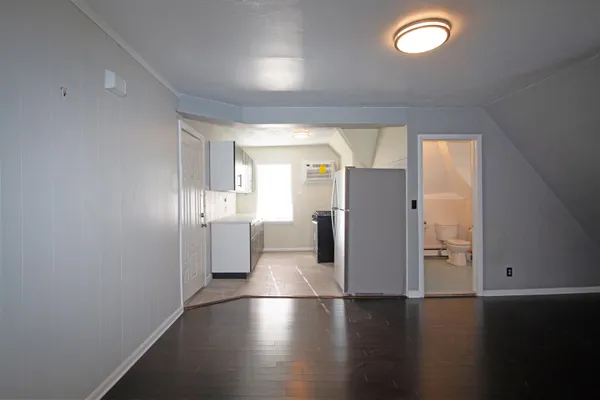 an empty room with wooden floor and a window