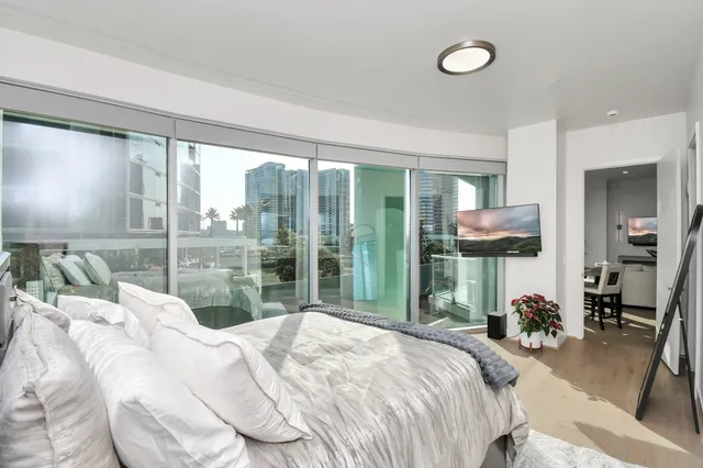 a bedroom with a bed and large windows