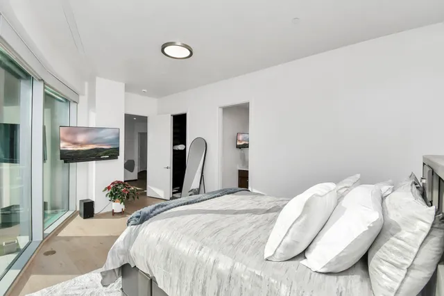 a bedroom with a bed and flat screen tv