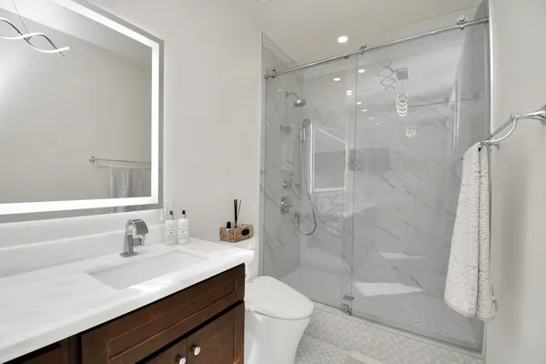 a bathroom with a sink a toilet and shower
