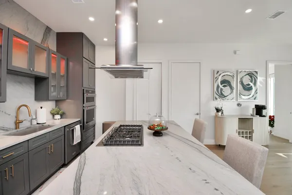 a kitchen with stainless steel appliances kitchen island granite countertop a stove a sink a refrigerator and cabinets
