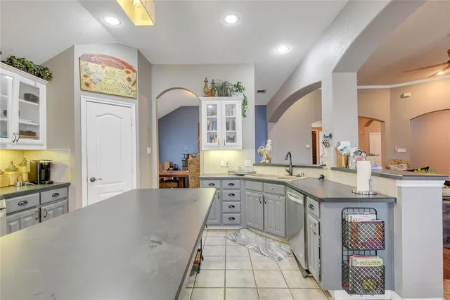 a large kitchen with a stove a sink dishwasher and a refrigerator with wooden floor