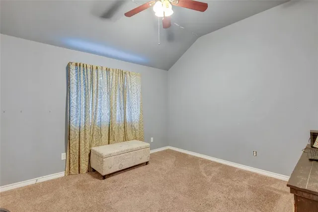 an empty room with a ceiling fan and window