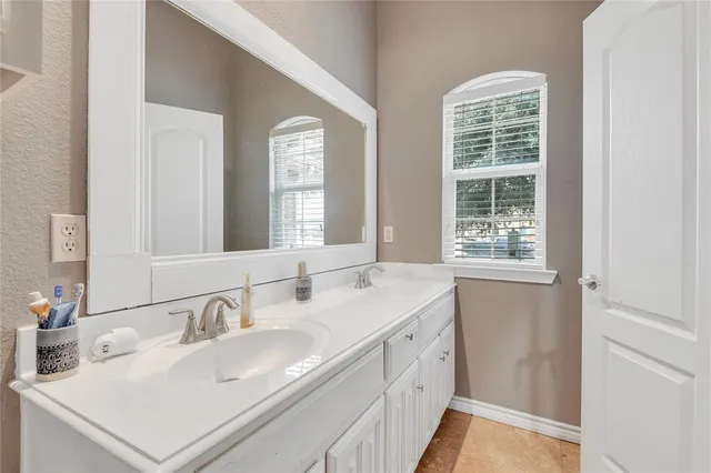 a bathroom with double vanity sink and a mirror