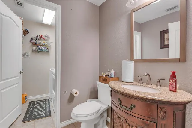a bathroom with a granite countertop toilet sink and mirror