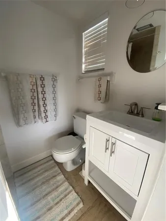a bathroom with a toilet a sink and a mirror
