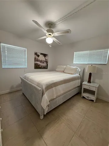 a bedroom with a bed and a ceiling fan