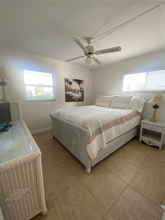 9200 Midnight Pass Road, Unit 10 Sarasota, FL 34242 - Photo 14 of 26 a bedroom with a bed and a chandelier