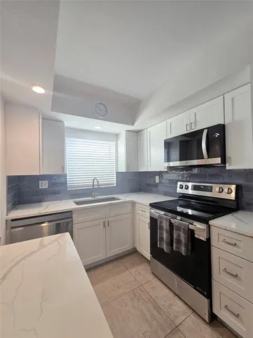 a kitchen with stainless steel appliances granite countertop a stove and a sink