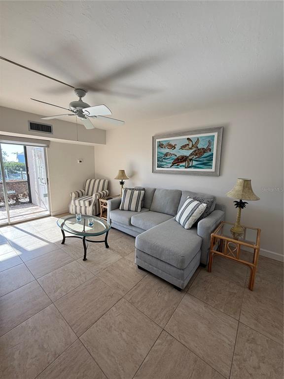 9200 Midnight Pass Road, Unit 10 Sarasota, FL 34242 - Photo 5 of 26 a living room with furniture and a chandelier