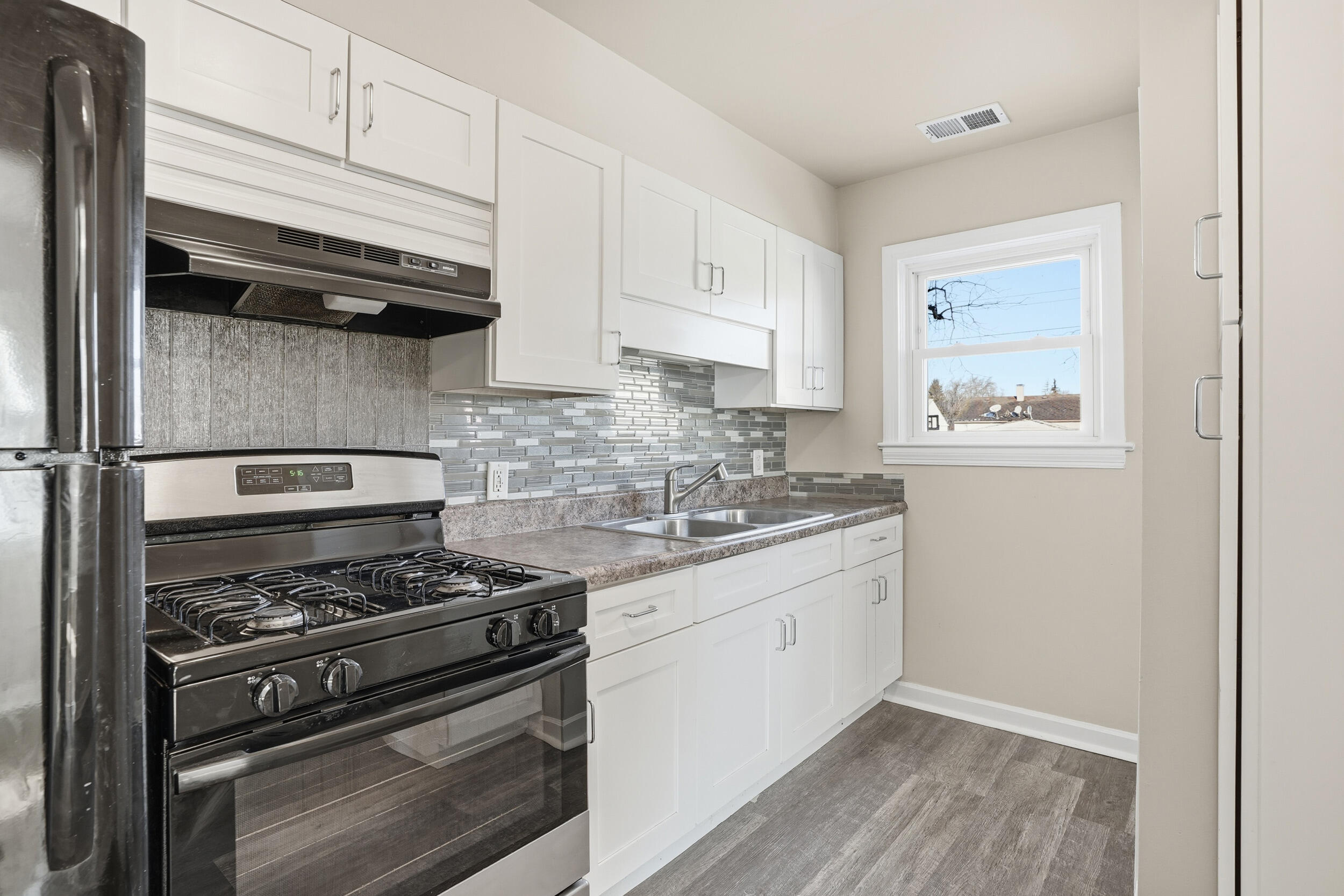 2731 Strong Street Highland, IN 46322 - Photo 7 of 16 a kitchen with stainless steel appliances granite countertop a sink stove and cabinets