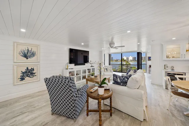 a living room with furniture kitchen view and a flat screen tv