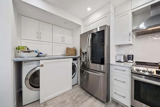 a kitchen with stainless steel appliances white cabinets and a refrigerator