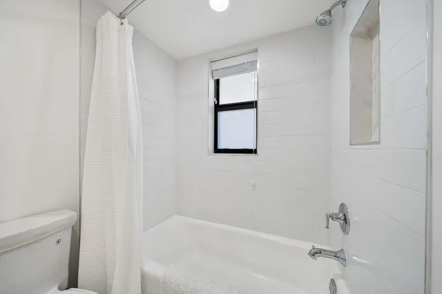 a bed room with a bed and a large window