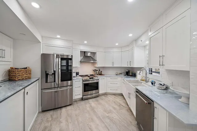 a kitchen with refrigerator a sink and wooden cabinets
