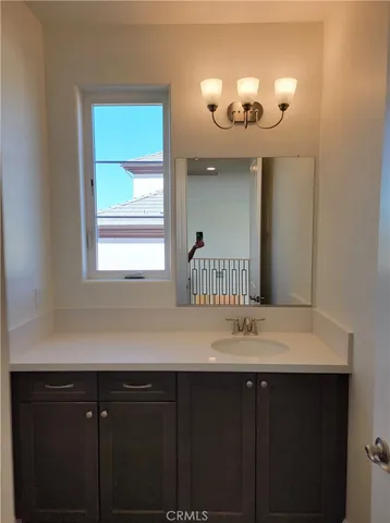 a bathroom with a sink vanity and a mirror