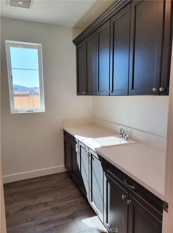 a kitchen with a sink cabinets and wooden floor